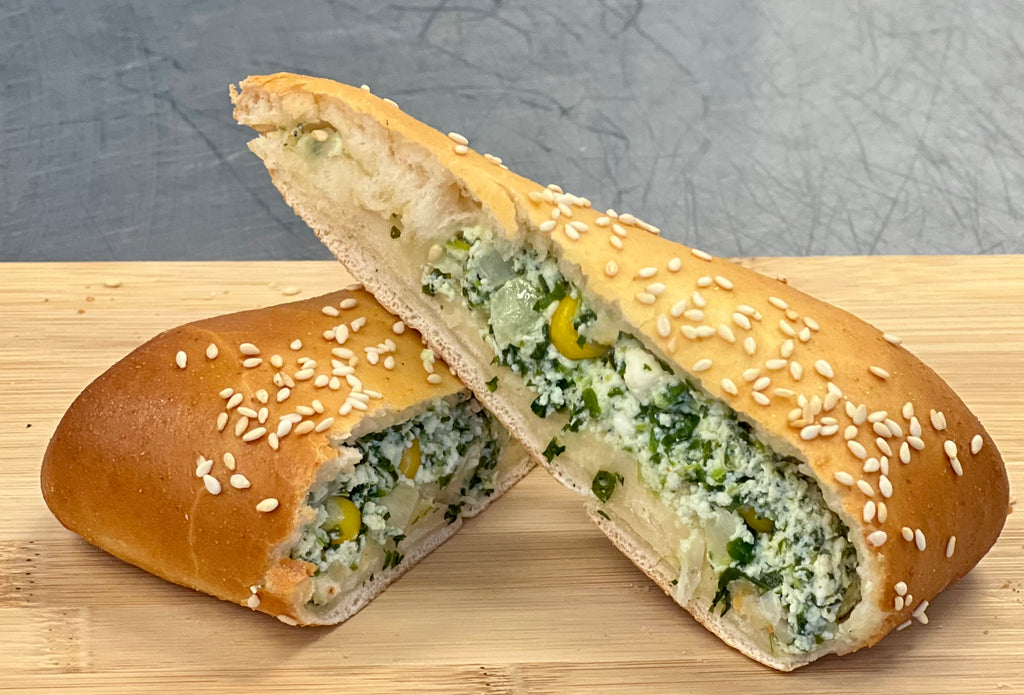 Sliced bread with spinach cheese and corn filling on a wooden board