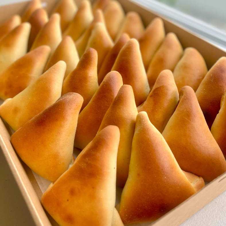 Box of triangular pastries with a golden-brown color.